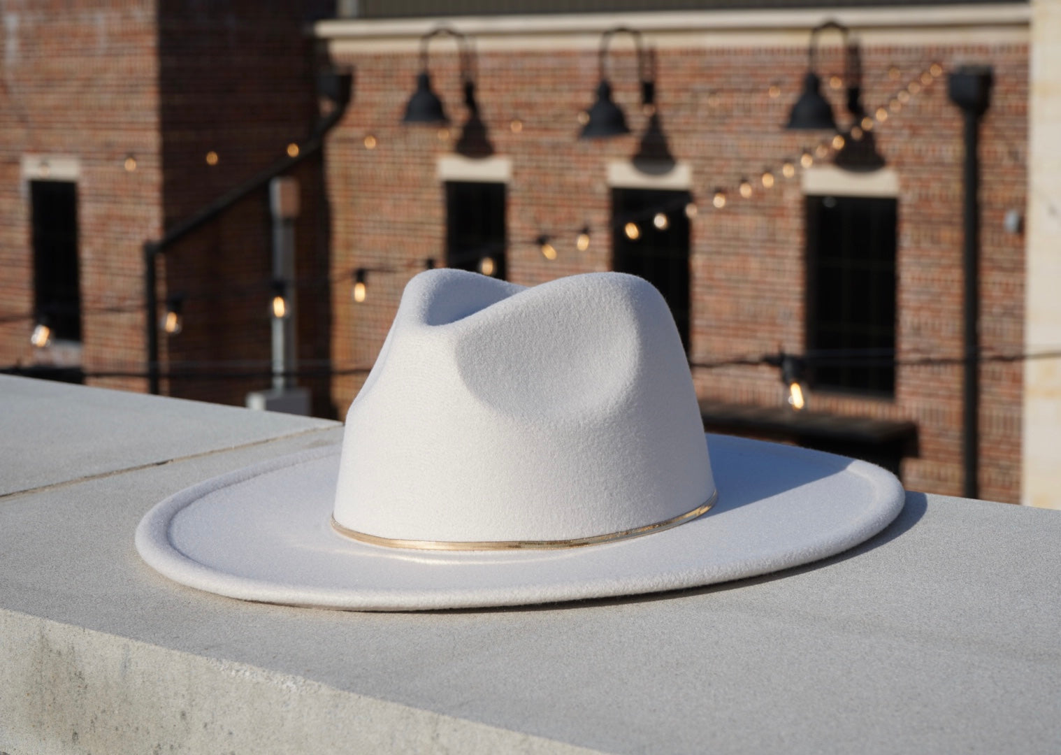 Hendrix wide brim hat with a gold herribone bone chain headband.