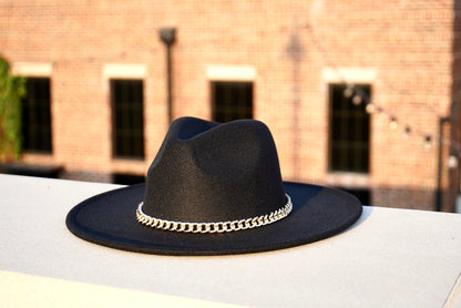 A black wide brim hat with a silver cuban link chain.