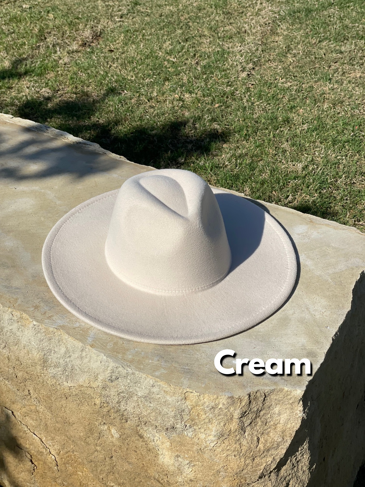 Cream colored wide brim fedora.