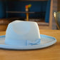 Product photo of a sky blue cureled brim fedora with a bowtie.